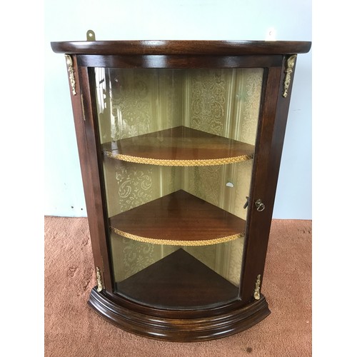 175 - GLAZED MAHOGANY BOW FRONT HANGING CORNER CUPBOARD WITH GILT METAL DECORATIVE MOUNTS