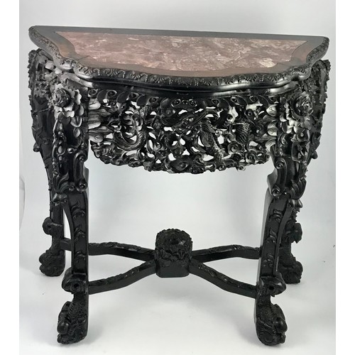 282 - HEAVILY CARVED ORIENTAL HARD WOOD CONSOLE TABLE OF SERPENTINE FORM HAVING INSET MARBLE TOP