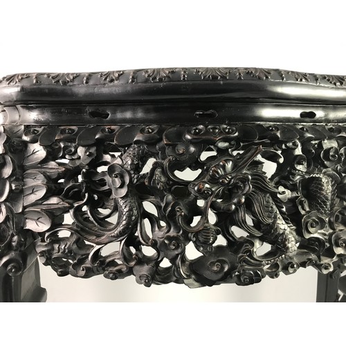 282 - HEAVILY CARVED ORIENTAL HARD WOOD CONSOLE TABLE OF SERPENTINE FORM HAVING INSET MARBLE TOP