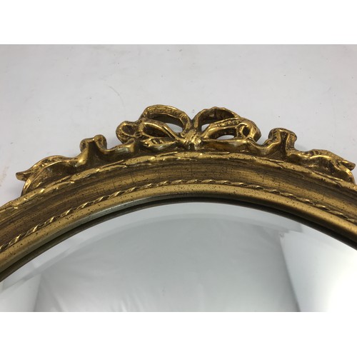 70 - OVAL MIRROR IN AN ORNATE FRAME