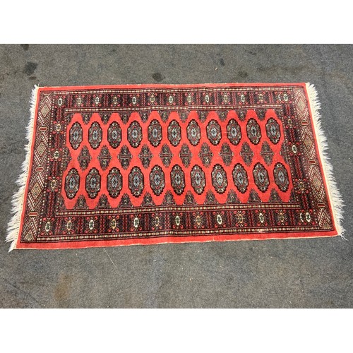 419 - RED GROUND RUG, APPROX. 163 cm X 96 cm.