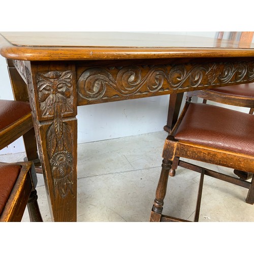 279 - CARVED OAK DINING TABLE ON CASTORS & SET OF 4 CHAIRS WITH LEWIS & GODFREY STROUD LABEL