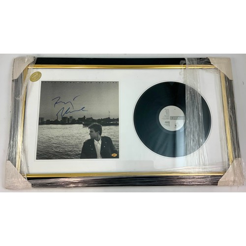 75 - FRAMED PICTURE WITH MOUNTED RECORD BRYAN ADAMS, INTO THE CITY, PHOTOGRAPH HAS SIGNATURE, CERTIFICATE... 