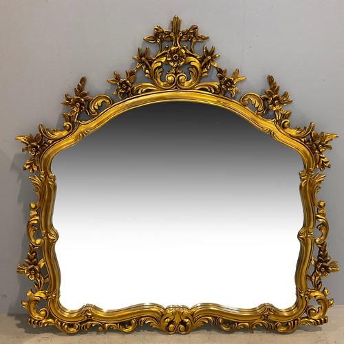 47 - A GILT FRAMED OVERMANTEL MIRROR, OPENWORK FLORAL AND FOLIATE SCROLL DECORATION AND OGEE SWEPT FRAME,... 