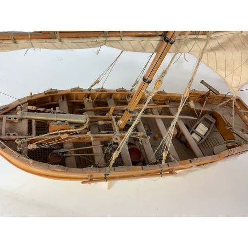 88 - 24” WOODEN MODEL OF A SAILING ‘GUN’ BOAT, WITH CANON & RED ENSIGN.