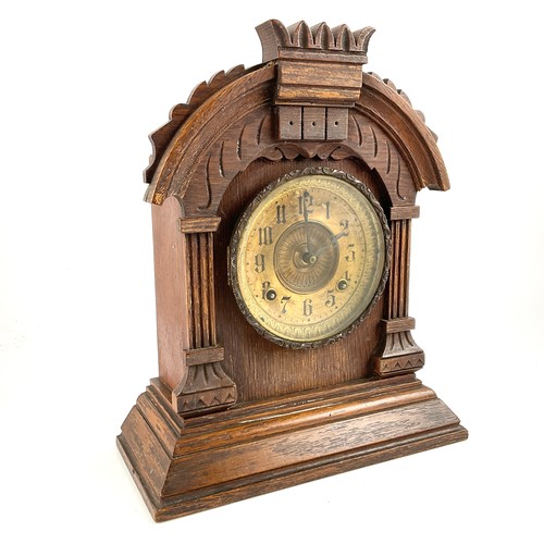 240 - A LATE 19TH CENTURY OAK CASED MANTEL CLOCK, BRASS DIAL BEHIND GLAZED DOOR, CARVED CURVED PEDIMENT AN... 