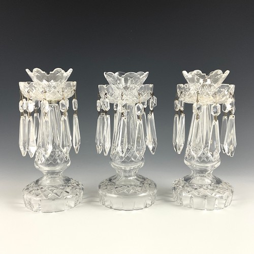 219 - THREE  WATERFORD CUT GLASS LUSTRES, WITH FLARED SCONCE AND CASTLEATED BOBECHE, ON INVERSE BALUSTER C... 