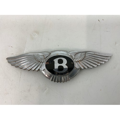 32 - BENTLEY CAR BADGE APPROX 16 CAM LONG, MOUNTS AT REAR, SOME CHIPPING TO THE ENAMEL AROUND THE B