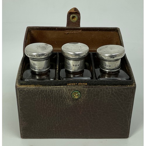 292 - ASPREY & CO. LEATHER CASE WITH 3 MATCHED BOTTLES EACH WITH A HALLMARKED SILVER TOP