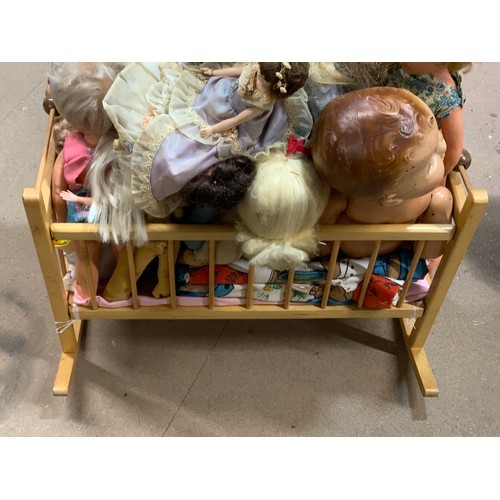 53 - A CHILDS MINI PLAY COT WITH A COLLECTION OF ASSORTED DOLLS