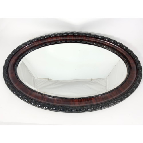 56 - OVAL BEVELLED GLASS MIRROR IN ORNATE FRAME 82cm LONG