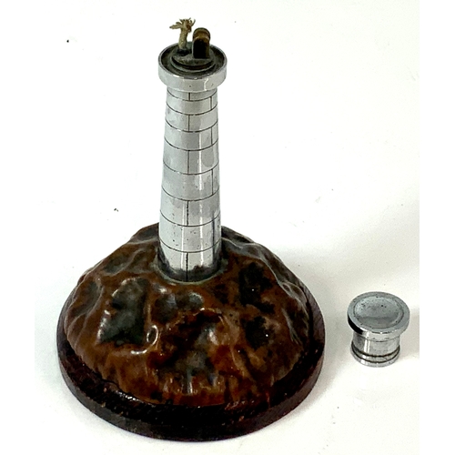 473 - AN INDIVIDUAL, TABLE LIGHTER IN THE FORM OF A LIGHTHOUSE, ON COPPER BASE