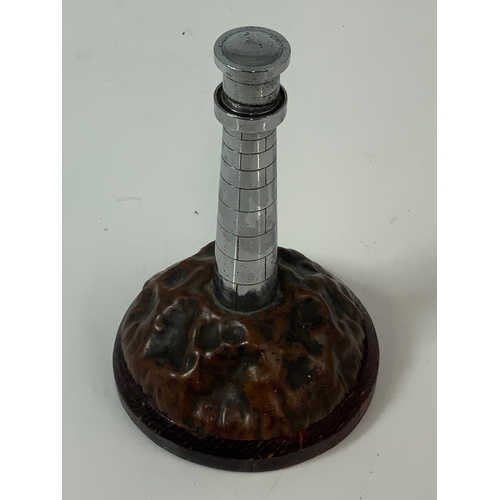 473 - AN INDIVIDUAL, TABLE LIGHTER IN THE FORM OF A LIGHTHOUSE, ON COPPER BASE