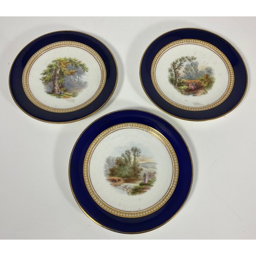 113 - THREE CABINET PLATES EACH HAND PAINTED WITH RURAL SCENE WITH JEWELLED DECORATION AND COBALT BLUE BOR... 