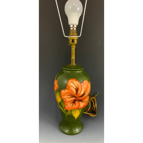 55 - LARGE MOORCROFT POTTERY TABLE LAMP IN THE HIBISCUS PATTERN ON GREEN GROUND