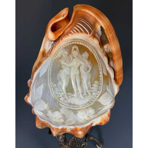 142 - WELL CARVED  LARGE CAMEO SHELL DEPICTING THREE CLASSICAL MAIDENS ON WHITE METAL STAND 20cm TALL