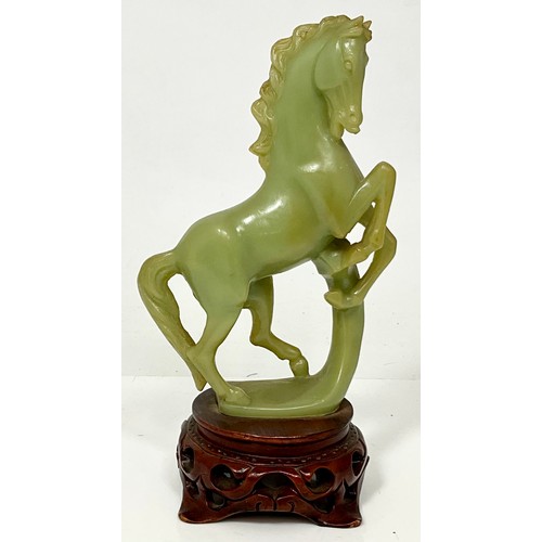 467 - CARVED JADE REARING HORSE ON CARVED WOOD BASE. WOOD BASE HEIGHT 5cm. HORSE HEIGHT 20.5cm