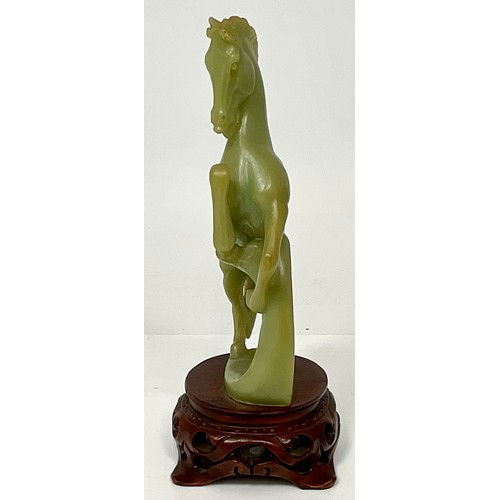 467 - CARVED JADE REARING HORSE ON CARVED WOOD BASE. WOOD BASE HEIGHT 5cm. HORSE HEIGHT 20.5cm