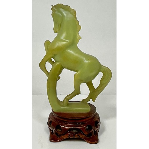 467 - CARVED JADE REARING HORSE ON CARVED WOOD BASE. WOOD BASE HEIGHT 5cm. HORSE HEIGHT 20.5cm