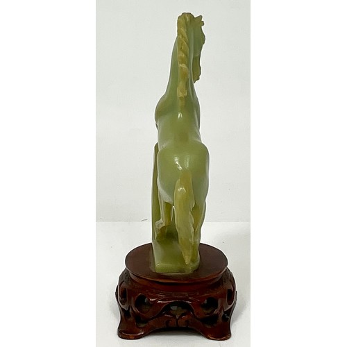 467 - CARVED JADE REARING HORSE ON CARVED WOOD BASE. WOOD BASE HEIGHT 5cm. HORSE HEIGHT 20.5cm