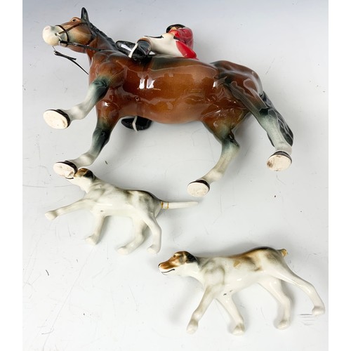 133 - PORCELAIN MODEL OF A HUNTSMAN ON HORSE & 2 FOX HOUNDS