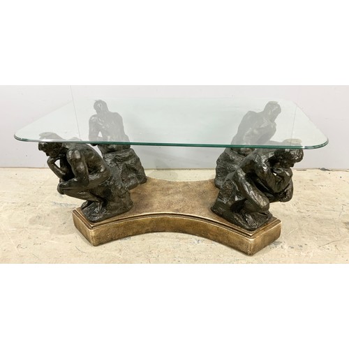 671 - A GLASS TOP COFFEE TABLE SUPPORTED ON FOUR 'THE THINKER' FIGURES