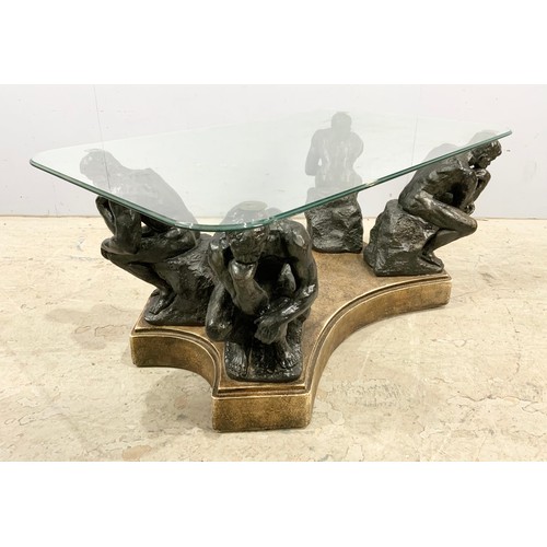 671 - A GLASS TOP COFFEE TABLE SUPPORTED ON FOUR 'THE THINKER' FIGURES