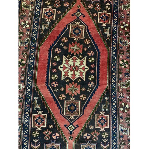 728 - RED GROUND RUG WITH GEOMETRIC PATTERN 210cm x 128cm