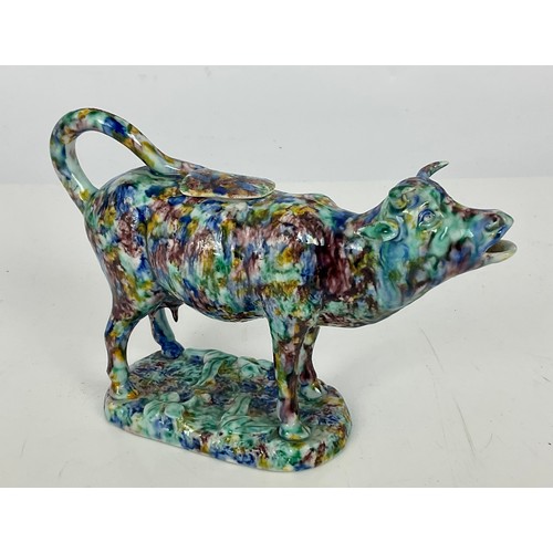 30 - AN EARLY 19TH CENTURY STAFFORDSHIRE PEARLWARE COW CREAMER WITH SPONGED BLUE, GREEN AND BROWN DECORAT... 