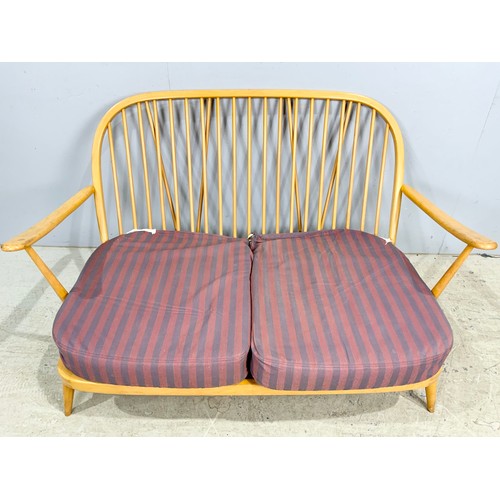 559 - AN ERCOL LIGHT ELM SPINDLE-BACK TWO-SEATER SETTEE