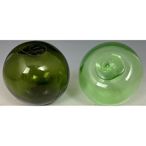 203 - TWO BLOWN GREEN GLASS FISHING FLOATS WITH SEALED PLUGS. LARGEST APPROX. 12cm DIA.