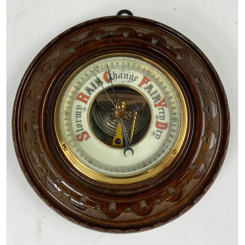 323 - ROUND ANEROID BAROMETER IN CARVED FRAME 18cm DIAMETER