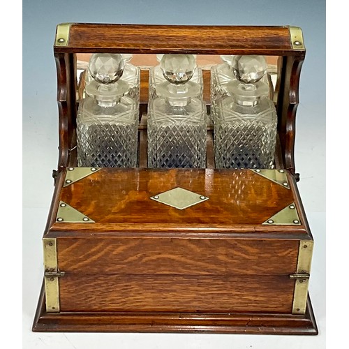 321 - A LATE VICTORIAN OAK CASED TANTALUS AND GAMES BOX