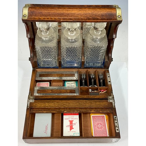 321 - A LATE VICTORIAN OAK CASED TANTALUS AND GAMES BOX