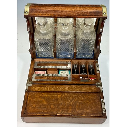 321 - A LATE VICTORIAN OAK CASED TANTALUS AND GAMES BOX