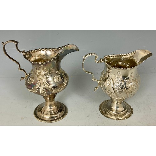 253 - 2 GEORGIAN PEDESTAL CREAM JUGS OF HELMET FORM WITH EMBOSSED DECORATION,, APPROX. 162.5g