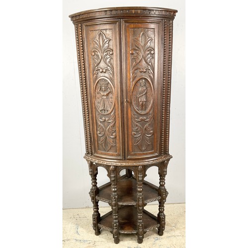 596 - STANDING OAK CORNER CUPBOARD WITH CARVED FLEMISH STYLE DECORATION 170cm TALL