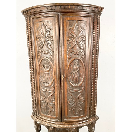 596 - STANDING OAK CORNER CUPBOARD WITH CARVED FLEMISH STYLE DECORATION 170cm TALL