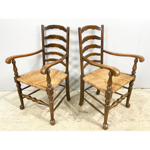 678 - A PAIR OF LADDER BACK CARVER / ARM CHAIRS WITH RUSH SEATS