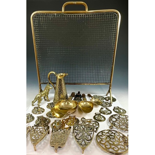 318 - MISC. BRASSWARE INC. A FIREGUARD, JUG, MEASURING SCOOPS, TRIVETS, HORSE BRASSES AND DOG FIGURE