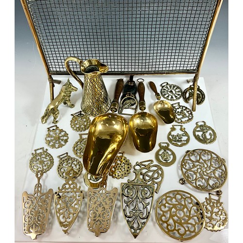 318 - MISC. BRASSWARE INC. A FIREGUARD, JUG, MEASURING SCOOPS, TRIVETS, HORSE BRASSES AND DOG FIGURE