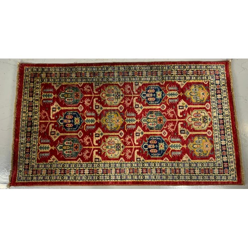 719 - RED GROUND RUG 154cm x 87cm