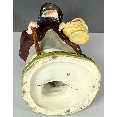 141 - EARLY 19TH STAFFORDSHIRE FIGURE OF OLD WOMAN WEARING A CLOAK WITH BASKET AND STICK