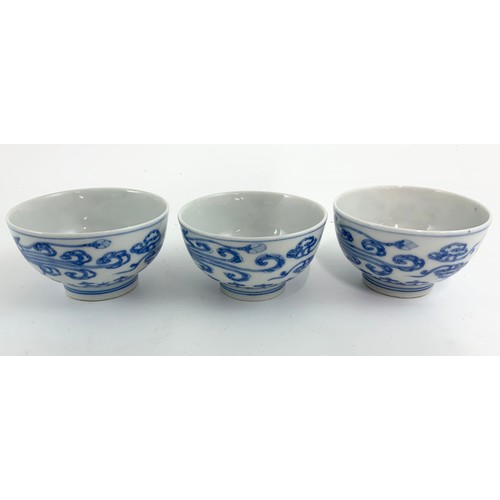 235 - THREE ORIENTAL BLUE AND WHITE TEA BOWLS EACH WITH A SIX CHARACTER MARK TOGETHER WITH A RICE BOWL