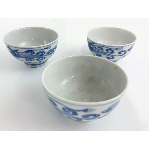 235 - THREE ORIENTAL BLUE AND WHITE TEA BOWLS EACH WITH A SIX CHARACTER MARK TOGETHER WITH A RICE BOWL