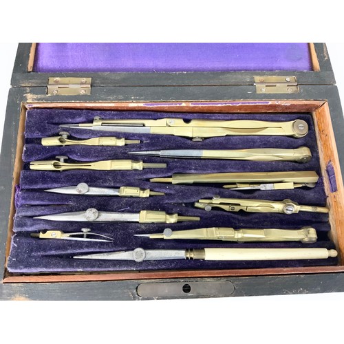 380 - CASED DRAWING SET TOGETHER WITH PAIR OF BRASS CANDLESTICKS