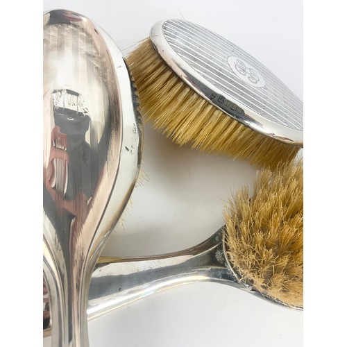 392 - TWO SILVER BACKED DRESSING TABLE BRUSHES WITH A SILVER PLATED EXAMPLE