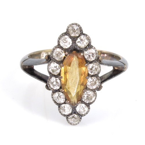 889 - 18CT GOLD RING WITH LANCET SHAPED YELLOW STONE, POSSIBILY A CITRINE, SET WITHIN A RING OF 15 DIAMOND... 