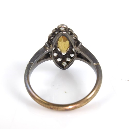 889 - 18CT GOLD RING WITH LANCET SHAPED YELLOW STONE, POSSIBILY A CITRINE, SET WITHIN A RING OF 15 DIAMOND... 