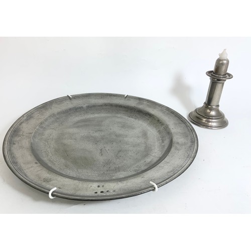 302 - LARGE PEWTER CHARGER TOGETHER WITH A PEWTER CANDLESTICK